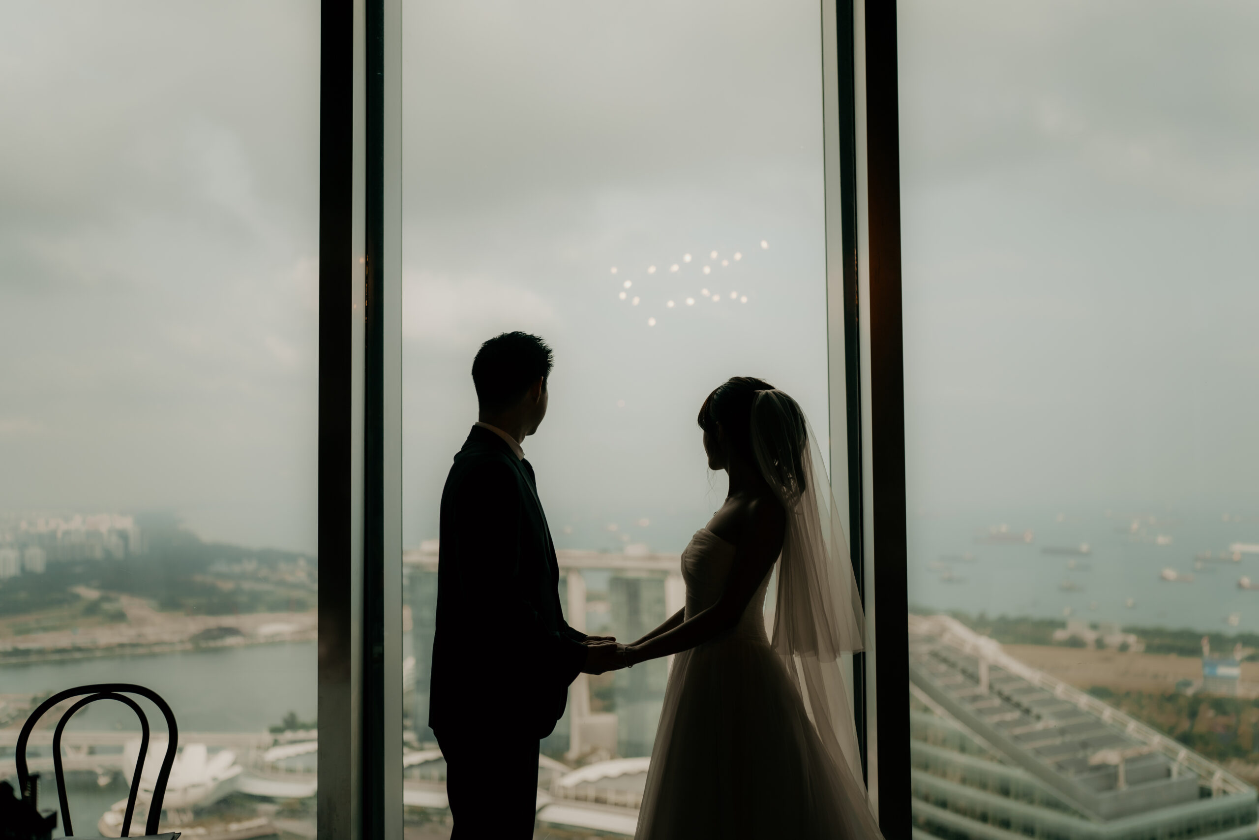 Bride and groom in silhouette against Singapore's Marina skyline at 1-Arden