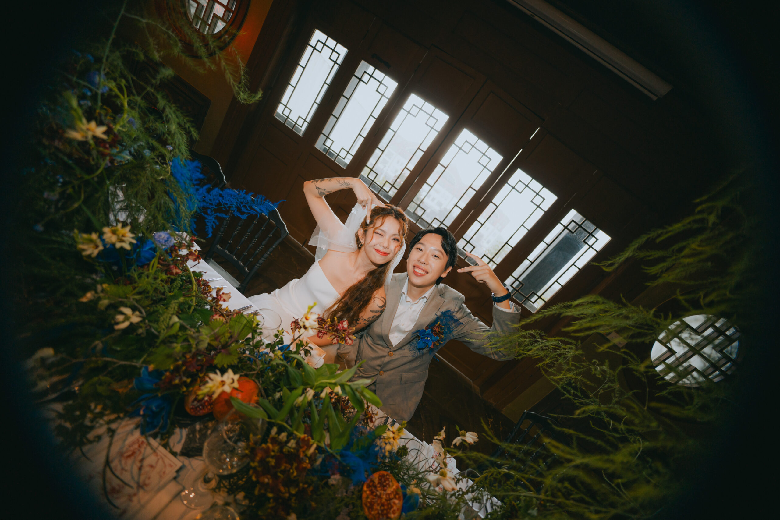 Newlyweds celebrating in a heritage hall with timber grille windows and bold florals